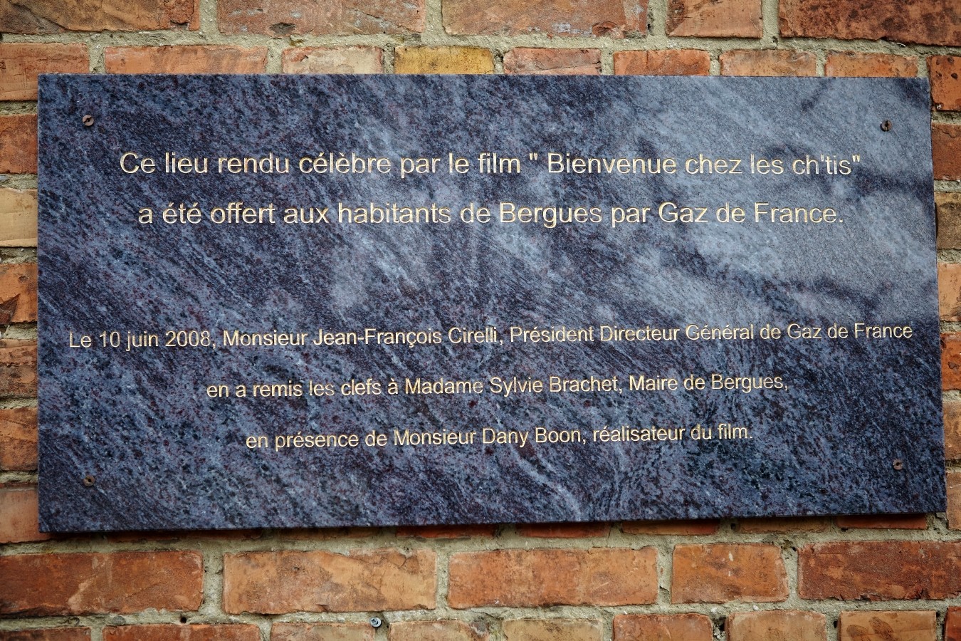 An der Hauswand erinnert eine Tafel...
