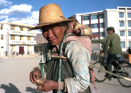 eine Tibeterin in Shigatse - dahinter die neuen Häuser der Han-Chinesen