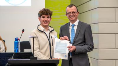 Simon Koch, Präsident des Jugendparlamentes Kanton Luzern, überreicht Staatsschreiber Vincenz Blaser die Petition über die Forderung nach praxisnaher Bildung zum Thema Erwachsenwerden. (Bild: zVg)