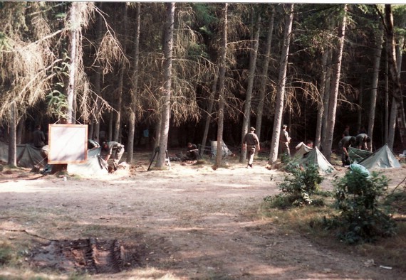 Hier sieht man das Bivuak im Hintergrund. Vor der Tafel am Baum wurde Unterricht erteilt.