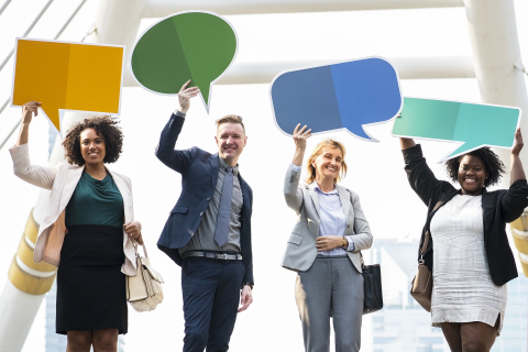 Symbolic image for technical translation services German, English, French in Dresden: people holding various forms of speech bubbles.