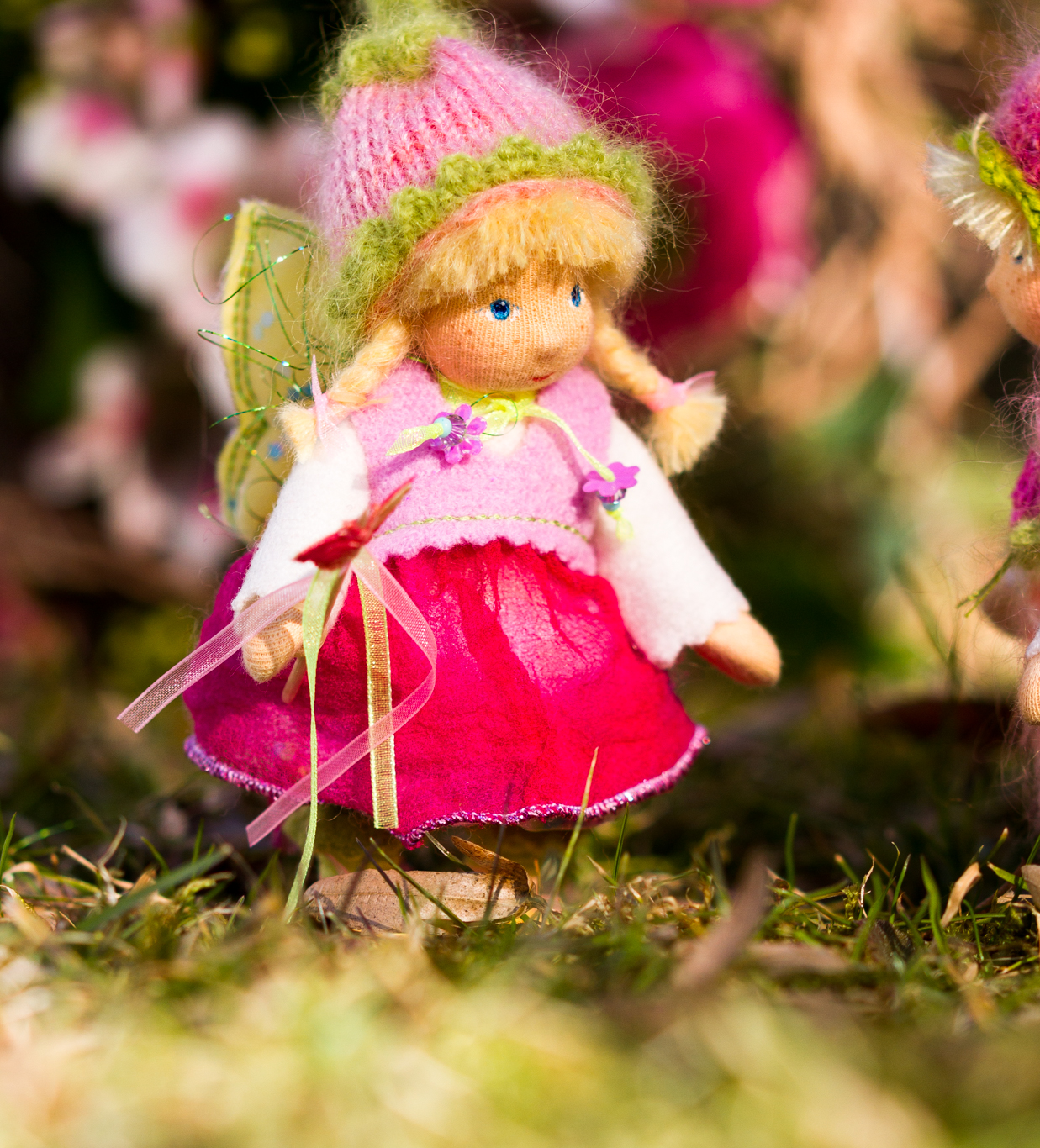 Elfe mit Stoff-Schmetterling auf Wiesenblumen