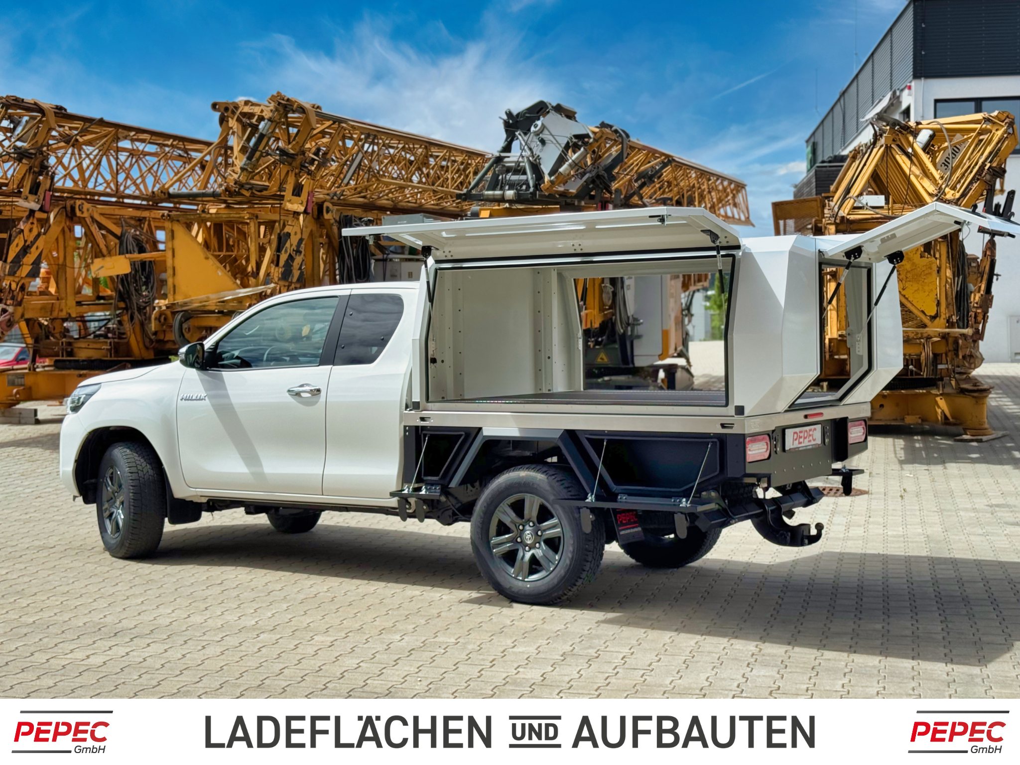 Toyota Hilux Pickup mit verlängertem Festaufbau, vier seitlichen Stauboxen und extra großem Heckauszug