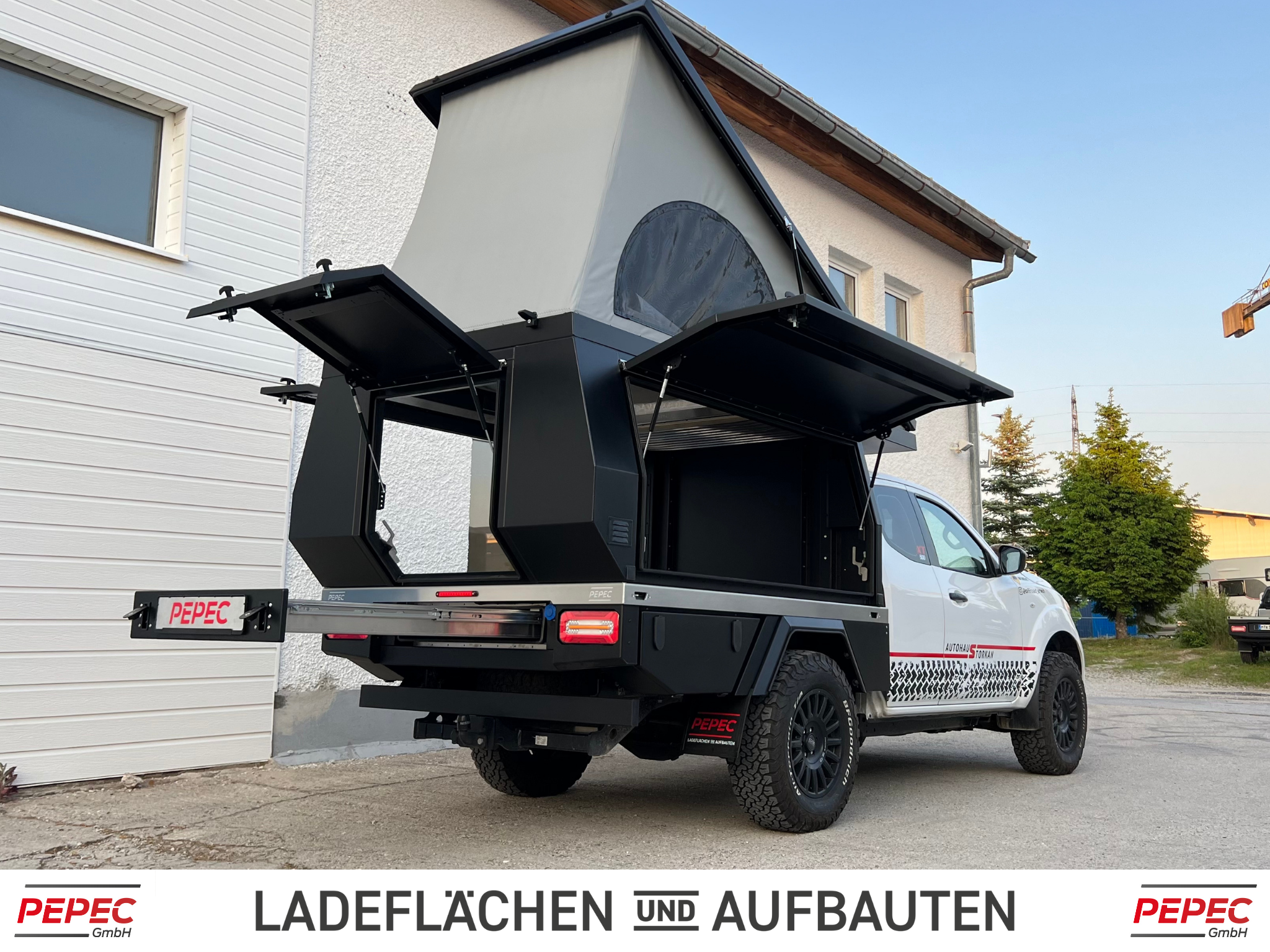 Nissan Navara Flatbed Camper mit Aufstelldach, geländegängig ausgestattet für Offroad-Camping und Abenteuerreisen