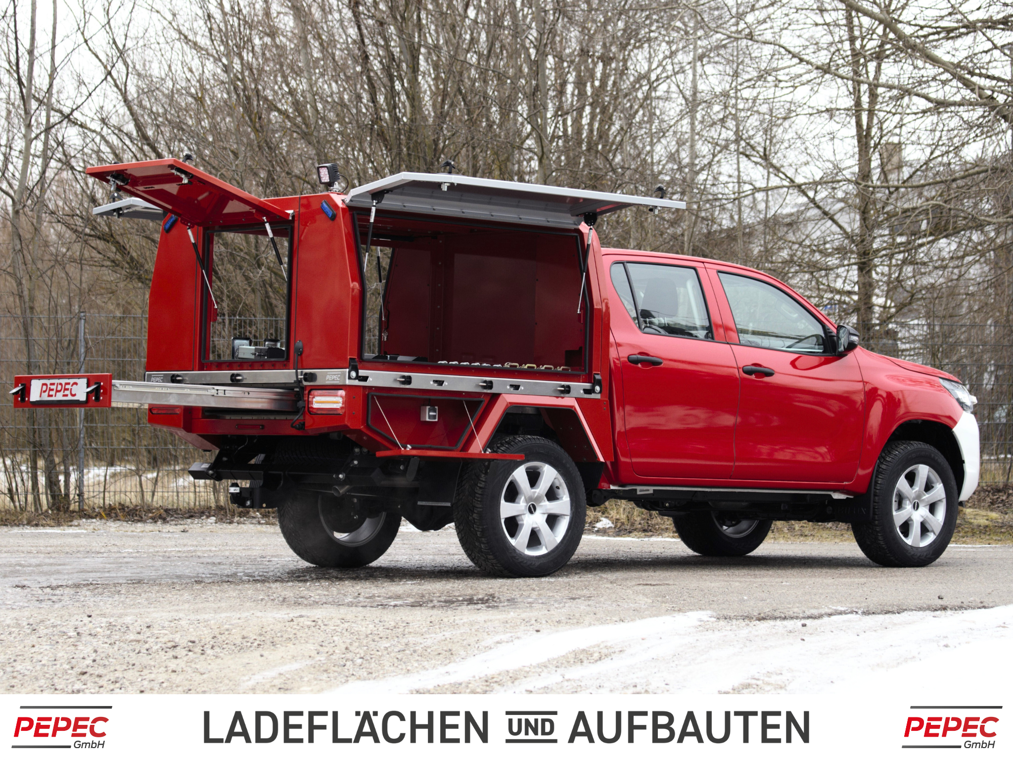 Toyota Hilux mit festverbautem Ladeflächen-Aufbau, Heckauszug, seitlichen Toolboxen und Zusatzbeleuchtung für Feuerwehr