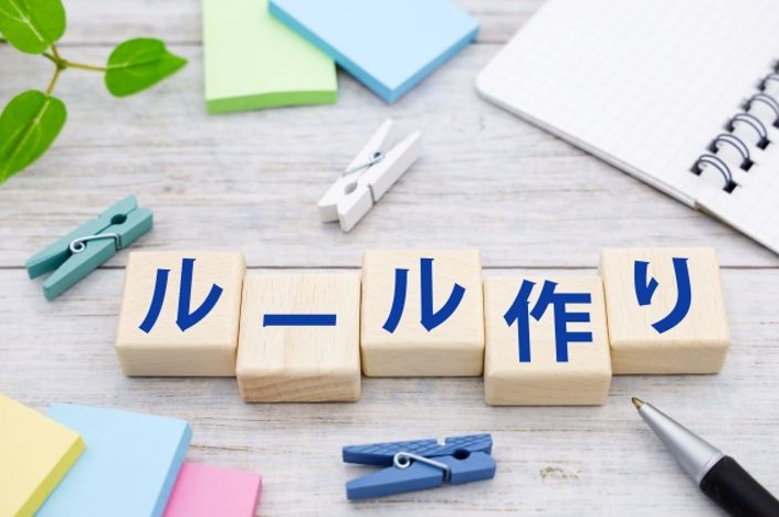 就業規則や社内ルール作成をイメージした写真。机の上に「ルール作り」と書かれた木製ブロックと文房具が並んでいる様子。