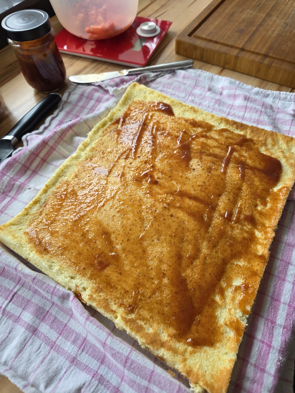 Biskuit für Erdbeer-Biskuitrolle mit Erdbeermarmelade bestichen