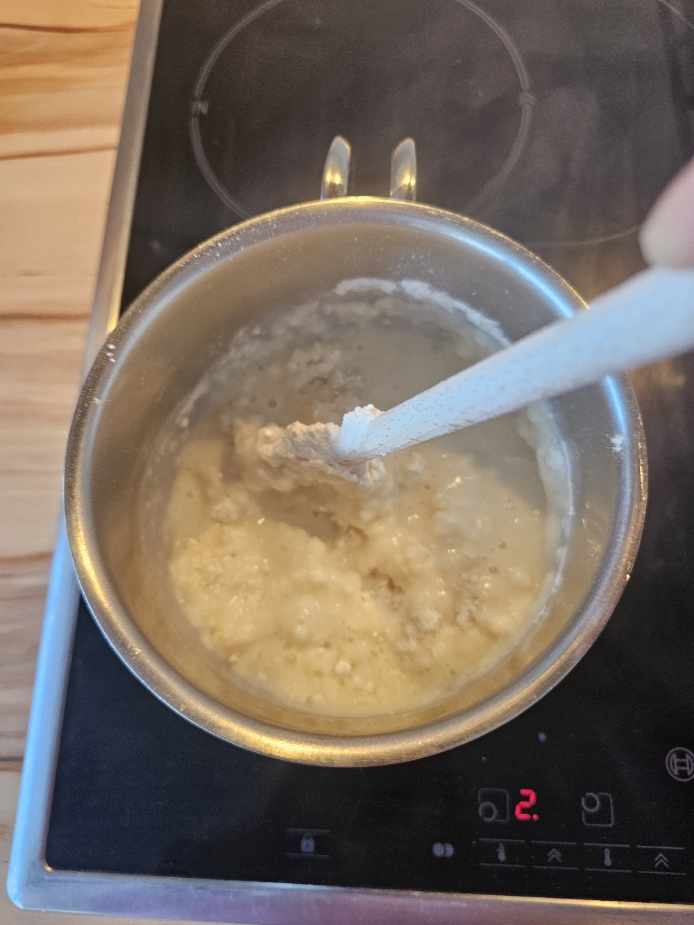 Mehl wird in kochendes Wasser und Butter für Brandteig angerührt