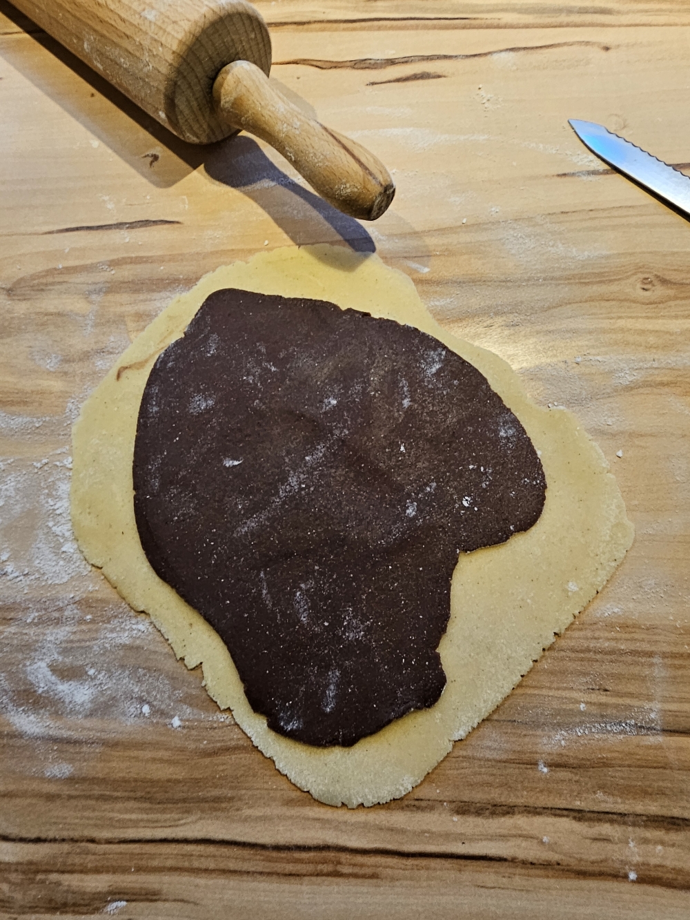 Ausgerollter Schokoladenteig auf dem Vanilleteig