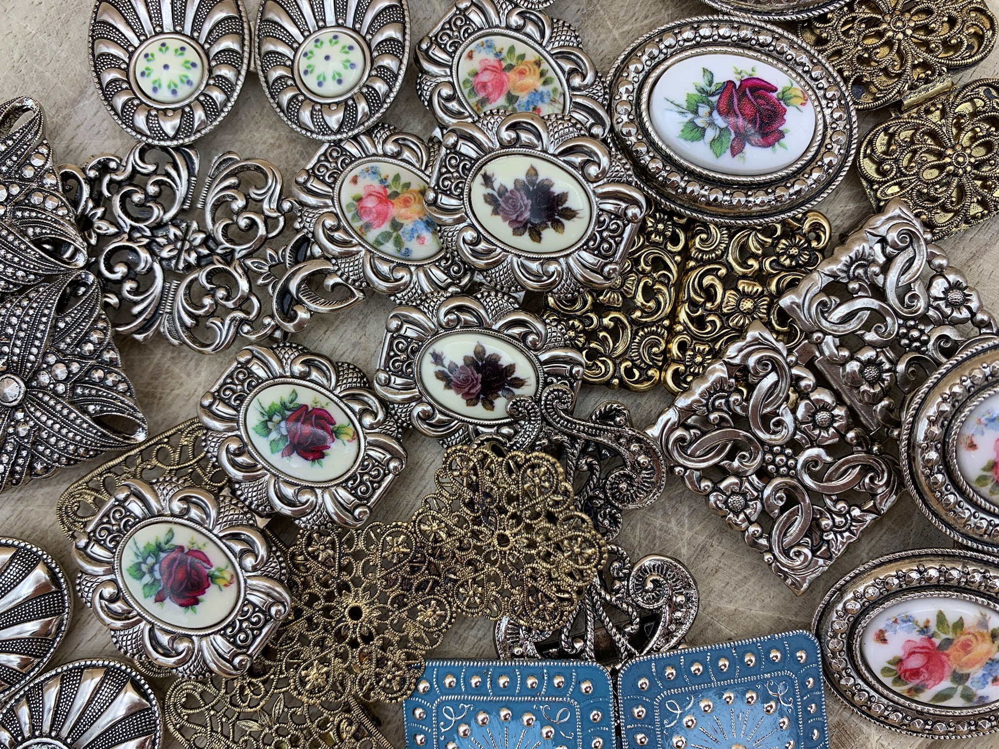 Verschiedene Trachtenschmuck-Schürzenschließen mit Rosen- und Blumenmotiven von der Trachtenschmuck-Manufaktur.