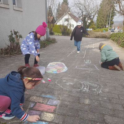 Children playing and exploring outdoors after lunchtime.