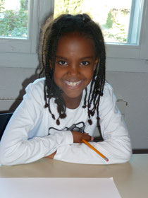 Child building confidence in writing during a Custom Kids English class.
