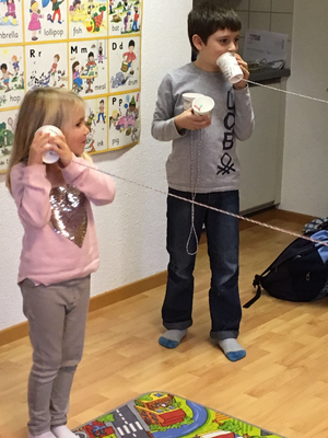 Children testing homemade string phones at Custom Kids Science Club
