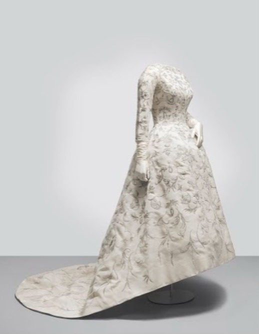 1957. Vestido de novia en shantung de color marfil con bordado erudito en hilo metálico dorado, entorchado sobre alma de seda y aplicación de lentejuelas de color nacarado dibujando motivos florales. El vestido, con escote a la caja, está entallado en el