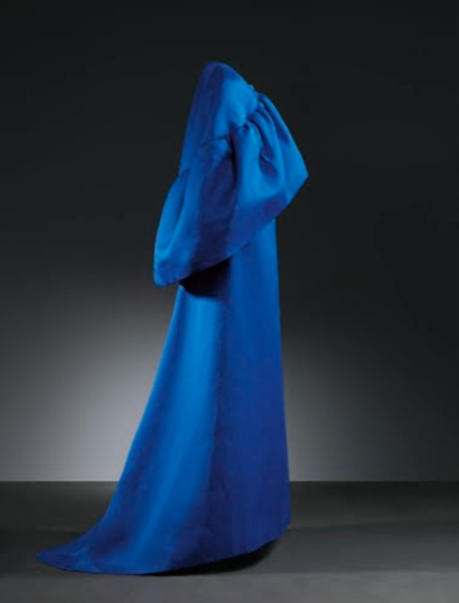 Vestido de noche largo, 1965. es largo con leve cola en la espalda. Pequeño escote en el delantero y pronunciado en la espalda. Sin mangas y con corte en la cintura. El cuerpo va entallado con pinzas y cierra en el centro de la espalda con corchetes y au