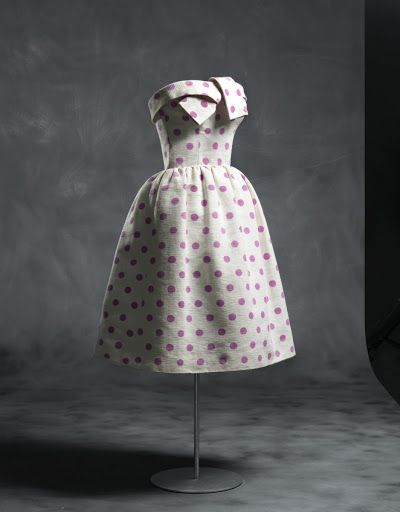 Vestido de cóctel 1955/ Con largo hasta la rodilla, el cuerpo va armado con corsé y ballenas. La falda está fruncida en la cintura. Se remata con escote palabra de honor con vuelta anudada en el centro del delantero. Va forrado en tafetán de rayón bla
