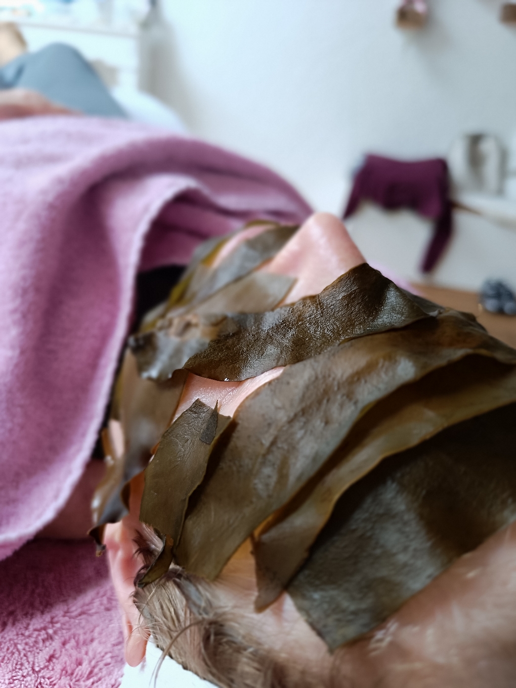 Gesichtsmaske mit frischen Algen im Gesicht