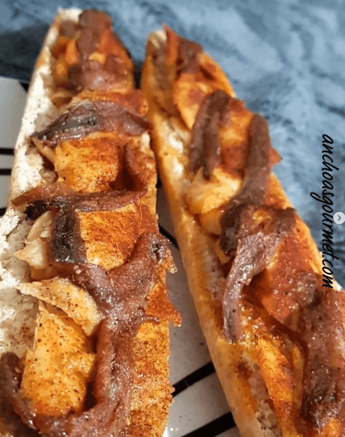 Un bocadillo de pan blanco con anchoas y bonito