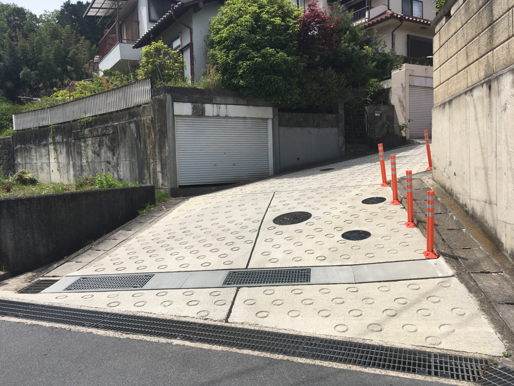 アスファルトではなく、丸いでこぼこがある道を登ります。この道をまっすぐ進む。