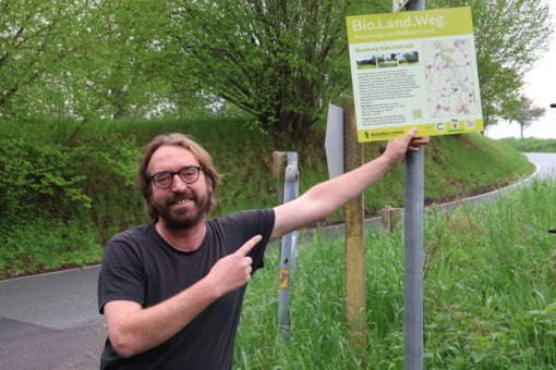 Martin Biedermann vom Bio-Weingut Cambium Compagnie mit Info-Tafel zum Rundweg Käbschütztal, Foto: EvW 2025