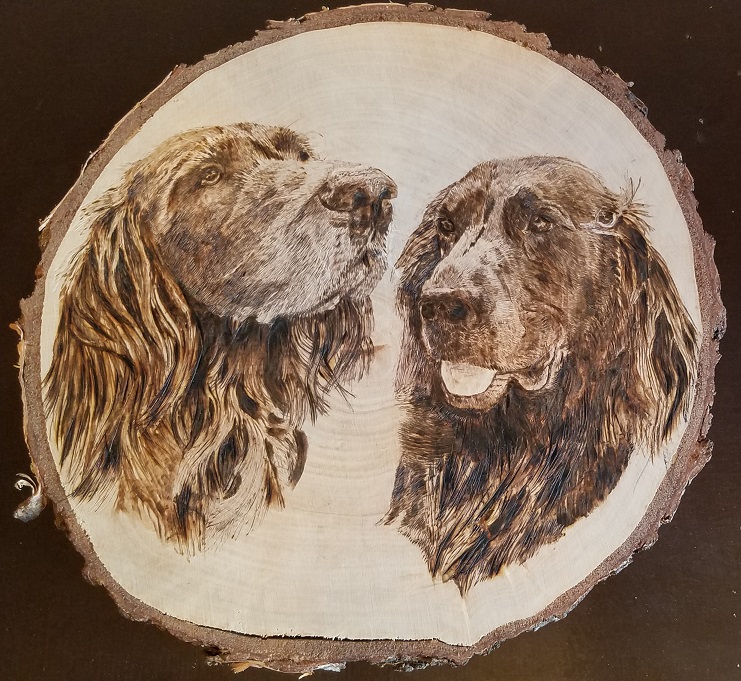 Brandmalerei der Hunde auf einer runden Birkenscheibe