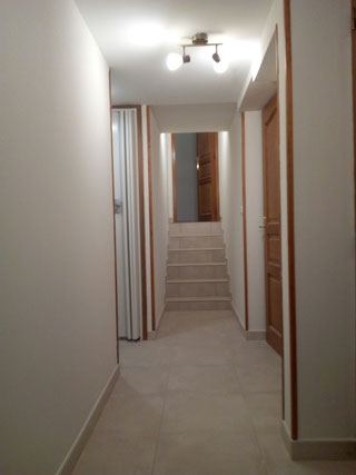 Photo montrant la reprise professionnelle d’un mur mal rénové par une pseudo entreprise multiservices à Puimisson, avec la pose de toile de verre (fibre de verre) et une finition peinture soignée pour des murs lisses, durables et esthétiques.
