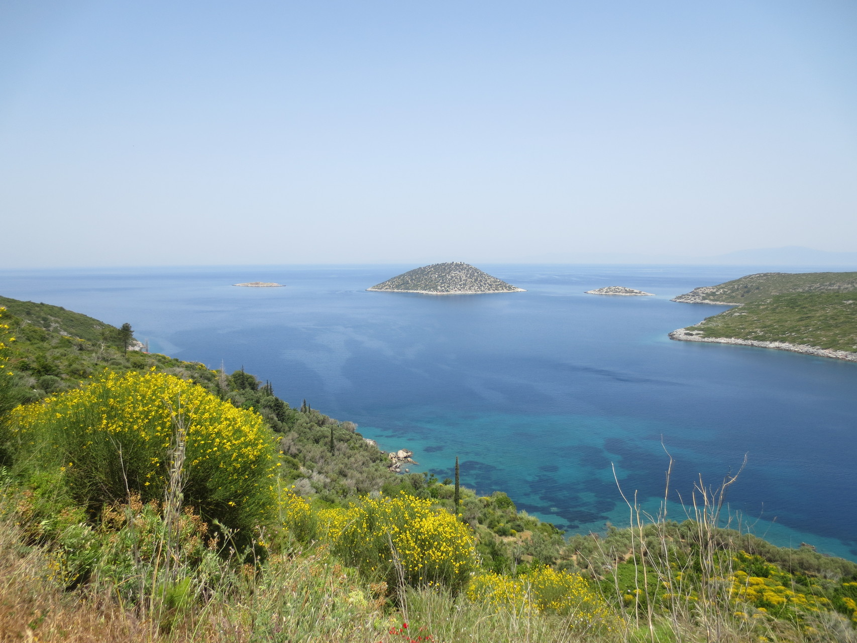 Im Nordosten des Eilands: Ormos Asprochorti.., hier gesellen sich unmittelbar vor der Küste die Kleinsteilande Agios Nikolaos (Mitte), Prasonissi (links) und ein namenloses Mikro-Eiland (rechts)