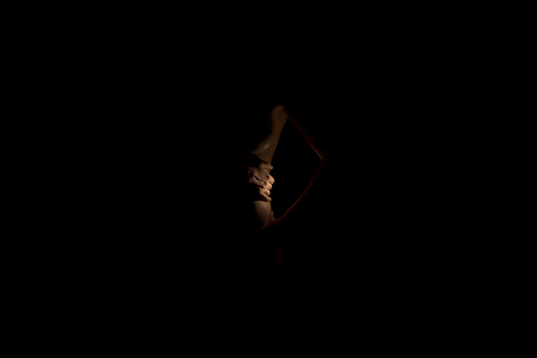 Fotografia fine art di nudo artistico porzione del corpo femminile nell'oscurità, dal portfolio 1217 di Alessandro Tintori