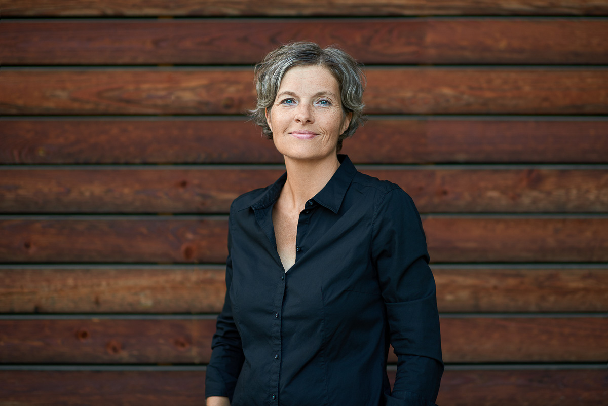 Businessportrait einer Frau vor Holzwand, Bilder für Website, Social Media und Presse