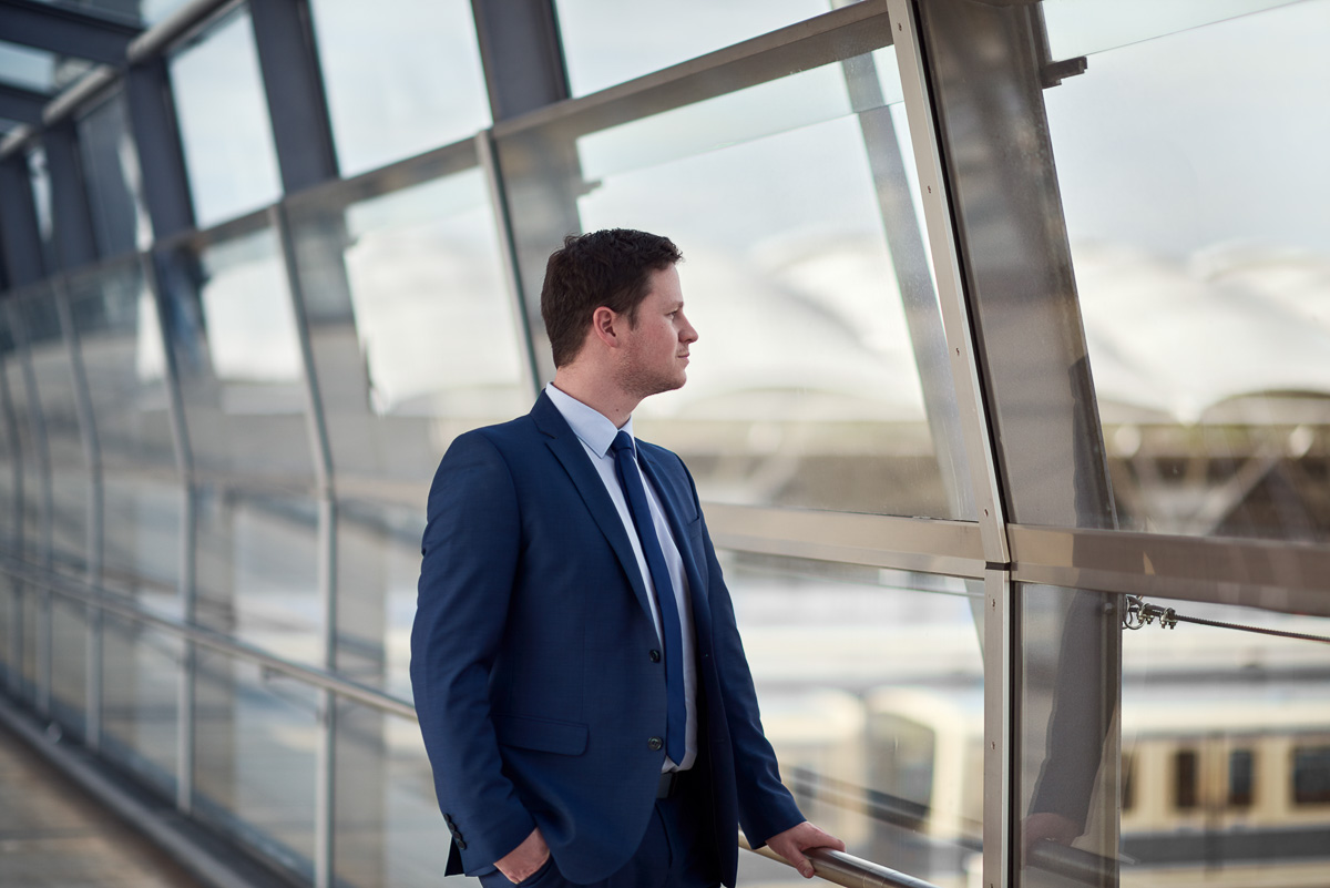 Businessportrait eines Mannes im Anzug im Glastunnel, moderner Corporate Look für Website und LinkedIn