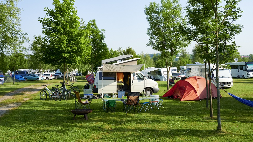 Campingplatz mit Zelten, Autos, Wohnmobilen und Wohnwagen