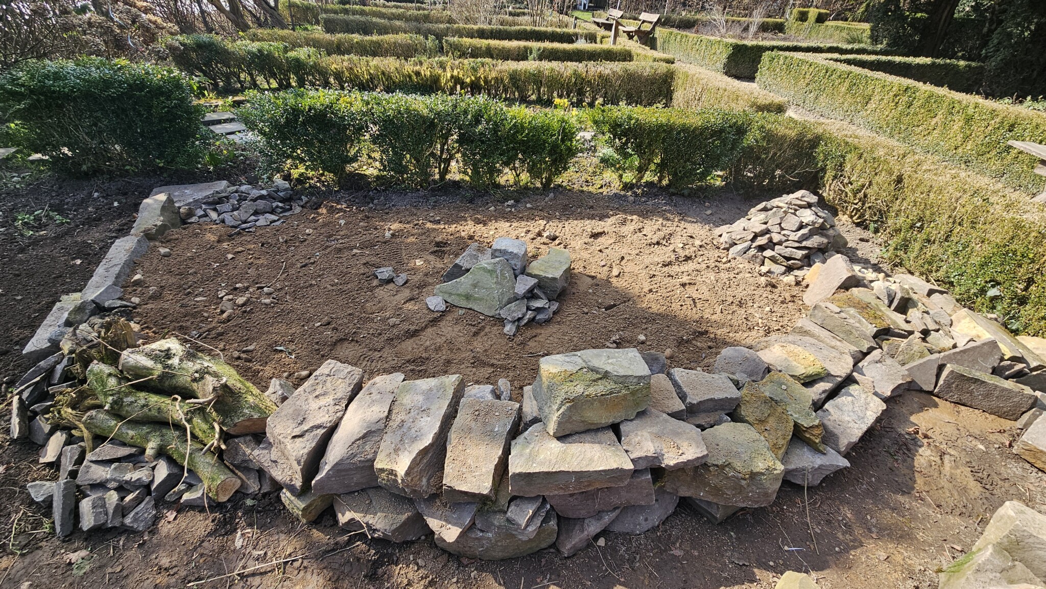 Magerbeet und Trockenmauer im Bau: Unterschiedliche Stapeltechniken, Steingrößen und Steinhaufen schaffen verschiedene Lebensräume. Rechts wurde noch eine mit Erde und Kies gefüllte Pyramide und daran angrenzend ein Spaltenbeet integriert.