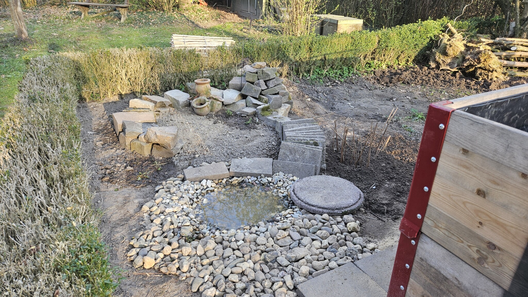 Überblick Kräutergarten und Wasserstelle:  Kurz nach dem Bau zeigt sich die Wasserstelle mit dem angrenzenden Kräuterbeet noch etwas kahl, lässt aber die baulichen Strukturen gut erkennen.