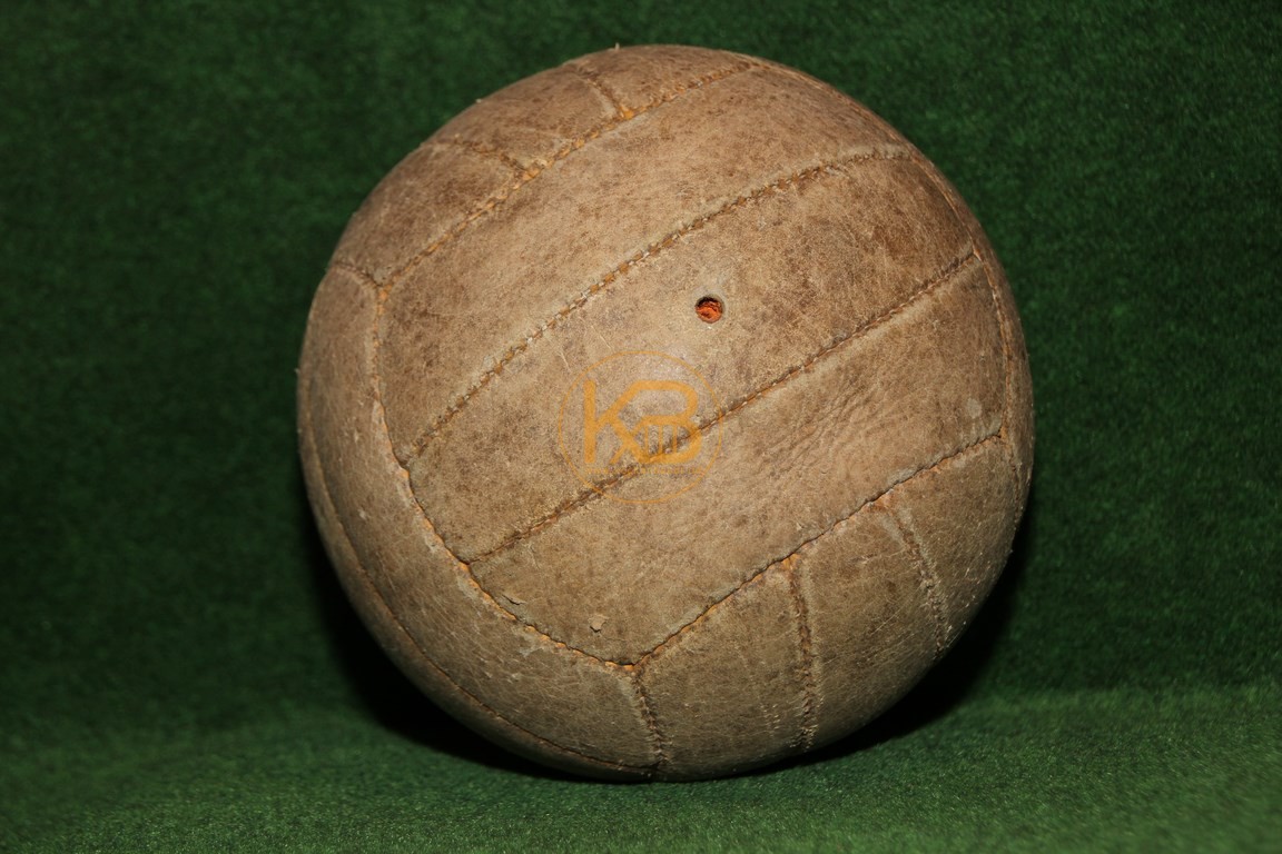 Alter Lederfußball der aus den bekannten Längsstreifen genäht ist.