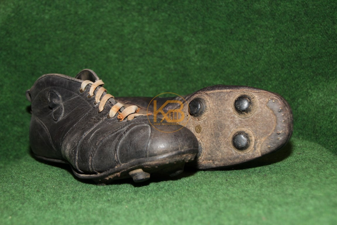 Hoher schwarzer Fußballschuh mit einer ersten Form der wechselbaren Schraubstollen.