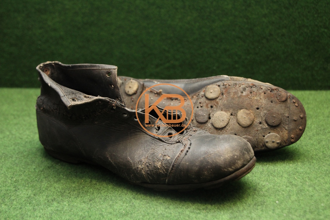 Alte Fußballschuhe mit Stahlkappe und genagelten Stollen aus den 1930er Jahren im stark bespielten Zustand.