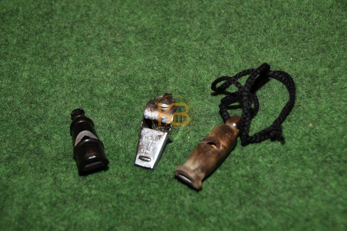 Drei alte Schiedsrichterpfeifen aus Hartplastik, Metall und Horn.