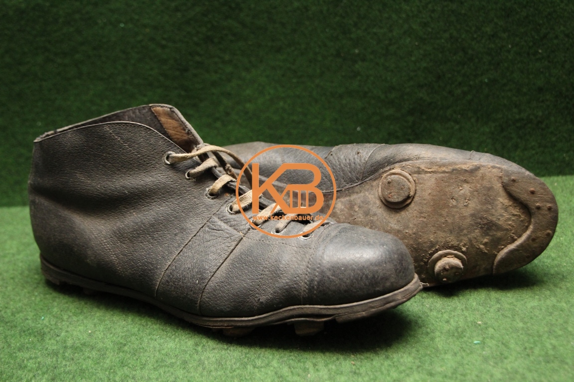 Alte Fußballschuhe mit Stahlkappe und genagelten Rundstollen. Die letzte Sohle ist eine Zeitung aus dem Jahr 1955. 1/2