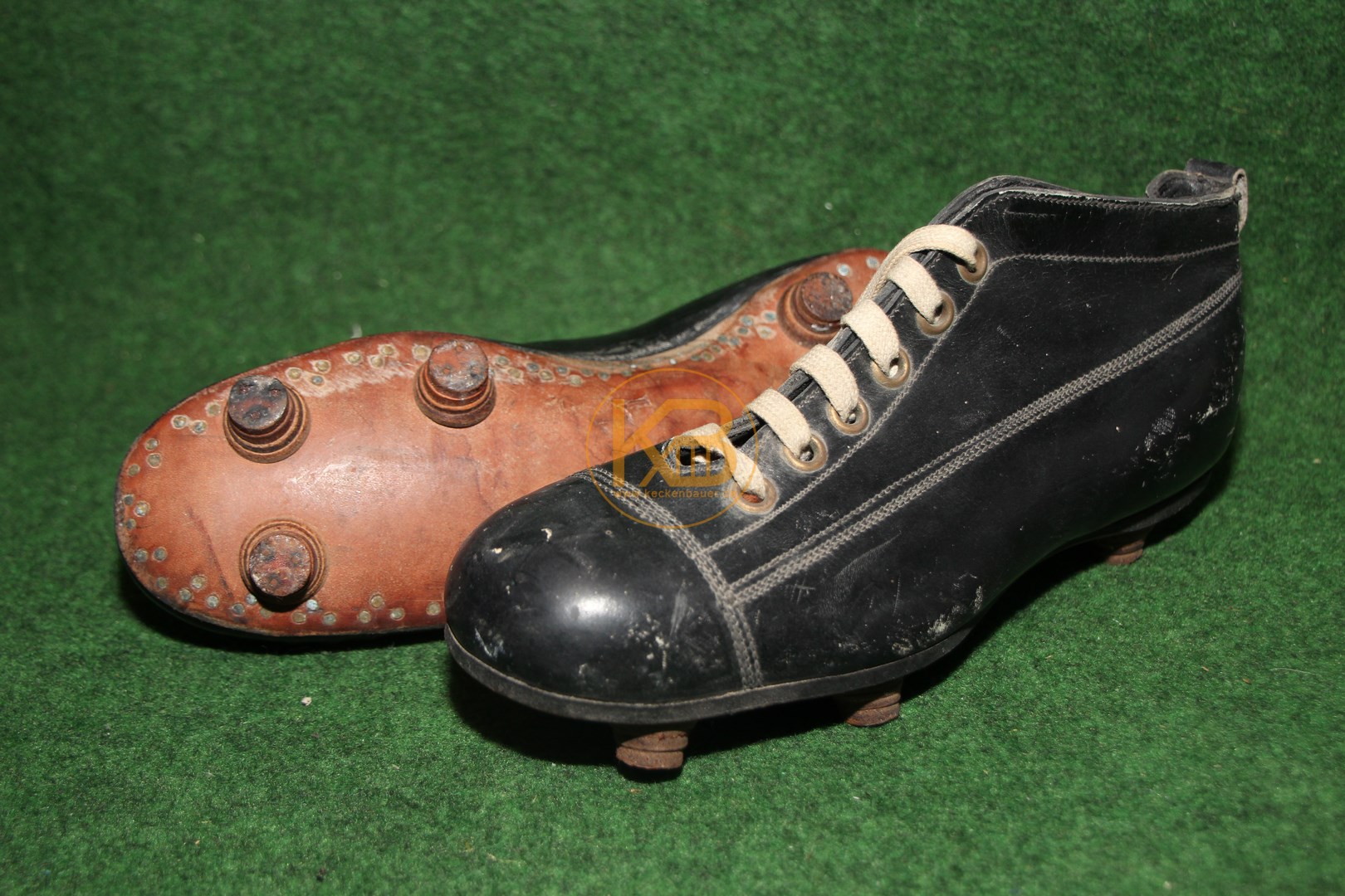 Schwarze hohe Fußballschuhe mit genagelten Stollen aus den 1920er Jahren. 