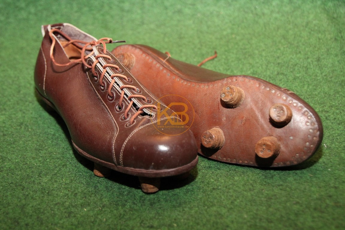 Alte braune flache Fußballschuhe mit genagelten Rundstollen vermutlich aus den frühen 1930ern.