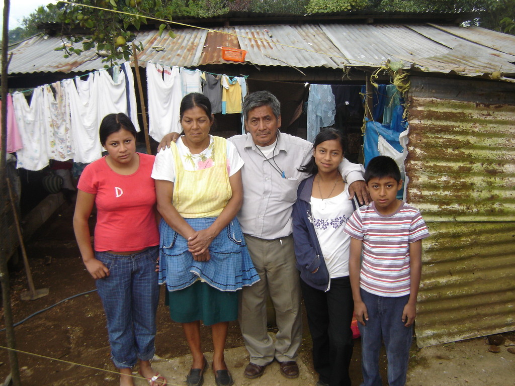 Mundo family in front of their old home