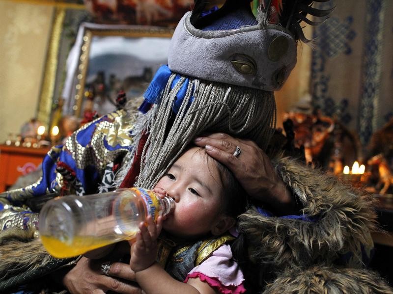 Ein mongolischer Schamane zelebriert ein Heilungsritual an seiner Nichte. Foto: How Hwee Young