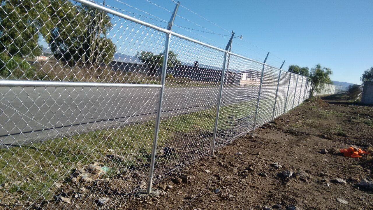 Malla ciclónica cal 11.5, de 2 metros de alto, con alambre de púas en la parte superior.