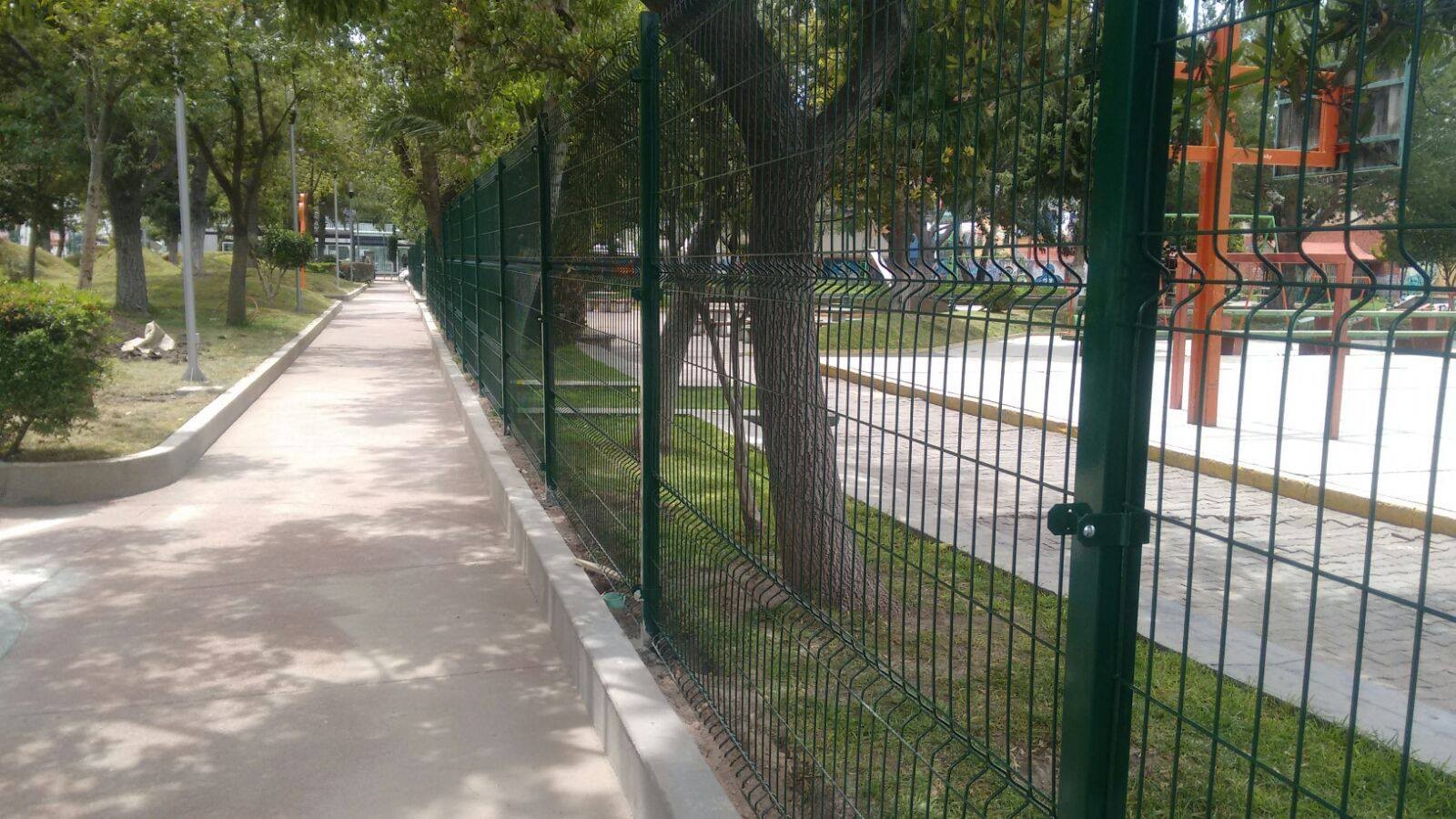 Reja de acero de 2 metros de alto. Postes y abrazaderás metálicas; todo en color verde.