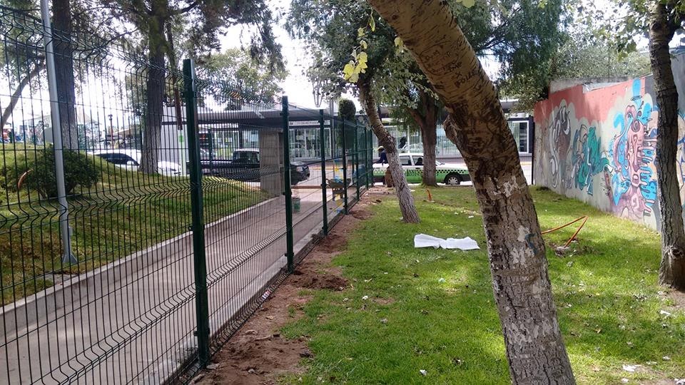 Reja de acero de 2 metros de alto. Postes y abrazaderás metálicas; todo en color verde.