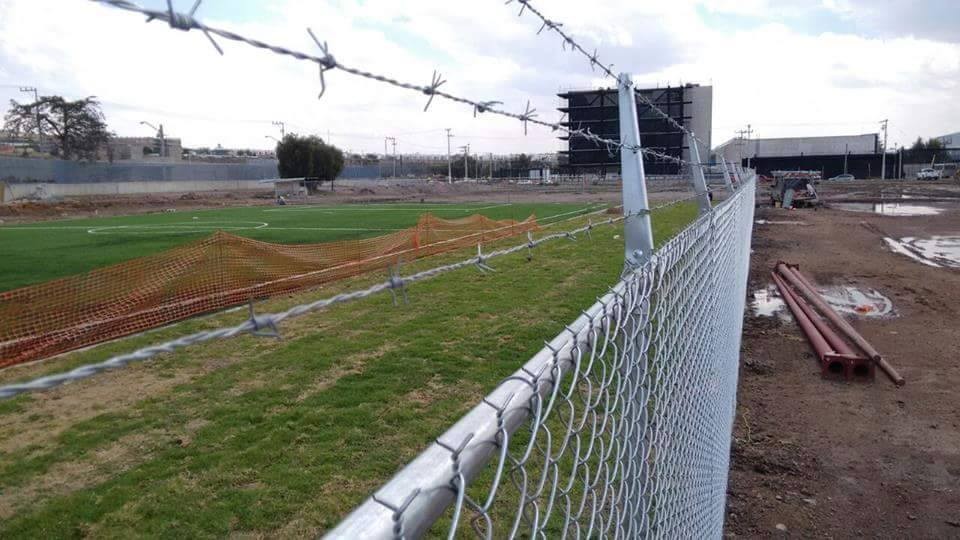 Malla ciclónica cal 11.5, de 2 metros de alto, con alambre de púas en la parte superior.