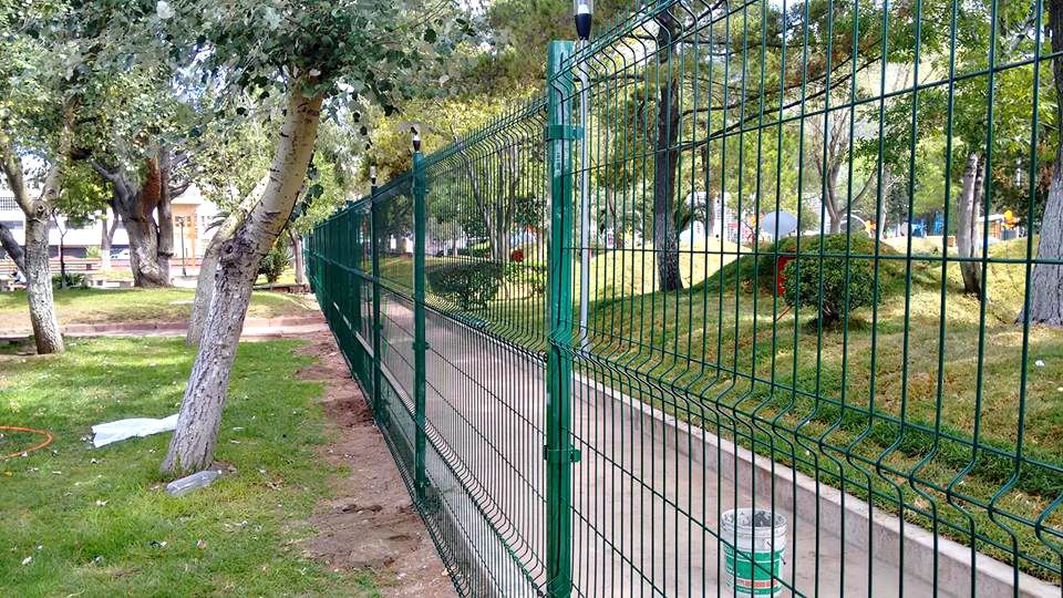Reja de acero de 2 metros de alto. Postes y abrazaderás metálicas; todo en color verde.