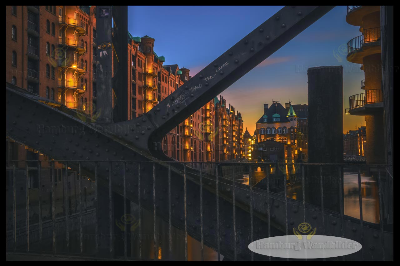 blick durch die bruecke auf das beleuchtete wasserschloss bei nacht hamburg wandbilder