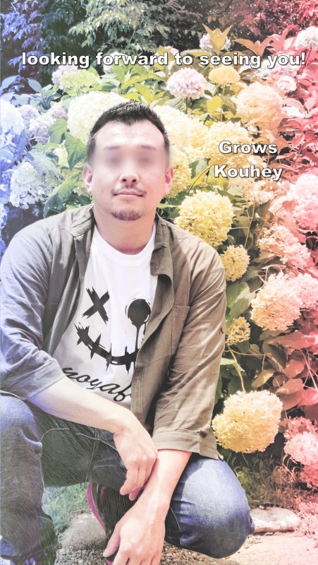 大阪のゲイマッサージGrows（グローズ）の男性セラピストKouhey（コウヘイ）。あじさいを背景に笑顔でお客様を歓迎する紹介画像。フレンドリーなメンズアロマ。