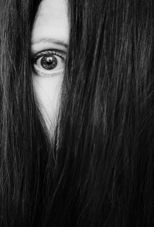 Manuela Deigert Bildsprache schwarzweißes Selbstportrait mit einem sichtbaren Auge in meinen von Haaren bedecktem Gesicht